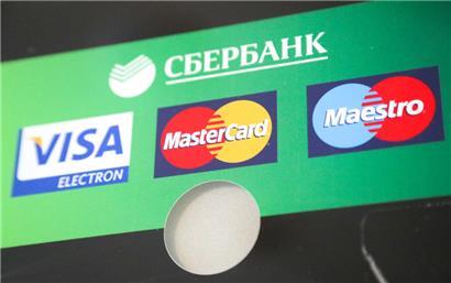 06.03.2022, Russland, St. Petersburg: Die Logos von Visa, Mastercard und Maestro sind auf einem Geldautomaten der Sberbank zu sehen
