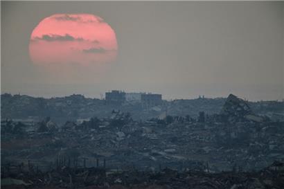 08.08.2025, Israel, —: Die Sonne geht hinter den Gebäuden unter, die während der israelischen Boden- und Luftoperationen im nördlichen Gazastreifen zerstört wurden, gesehen vom Süden Israels aus. Foto: Leo Correa/AP/dpa +++ dpa-Bildfunk +++
