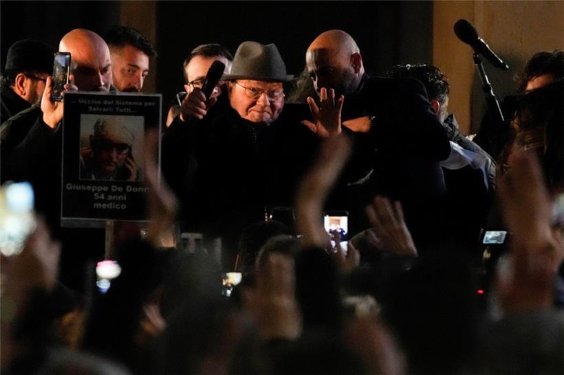 15.01.2022, Italien, Mailand: Luc Montagnier (M), Virologe und Nobelpreisträger aus Frankreich, winkt Protestteilnehmer zu, nachdem er während einer Demonstration gegen die Corona-Maßnahmen der Regierung eine Rede gehalten hat
