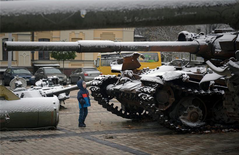 17.11.2022, Ukraine, Kiew: Ein Kind betrachtet eine Ausstellung von zerstörten russischen Panzern und gepanzerten Fahrzeugen
