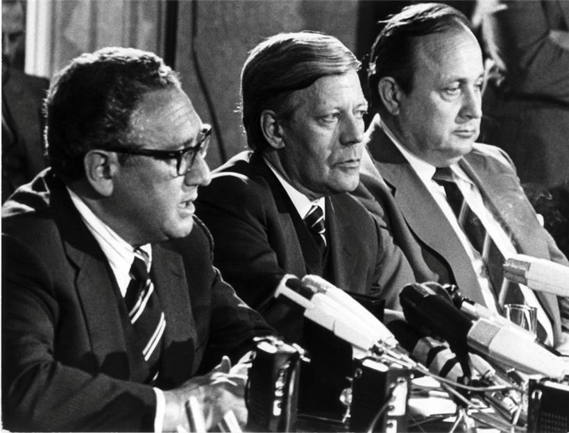 1976, Hamburg: Der damalige US-amerikanische Außenminister Henry Kissinger, der damalige Bundeskanzler Helmut Schmidt (SPD) und der damalige Bundesaußenminister Hans-Dietrich Genscher (FDP) sitzen bei einer Pressekonferenz nebeneinander (von links)
