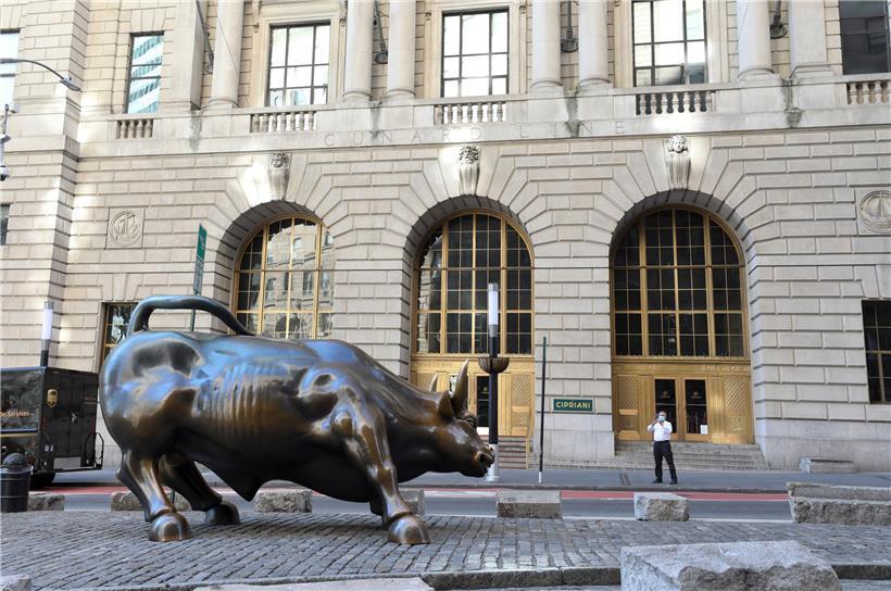 24.03.2020, USA, New York: Ein Mann fotografiert den «Wall Street Charging Bull» in New York. Foto: Wang Ying/XinHua/dpa +++ dpa-Bildfunk +++
