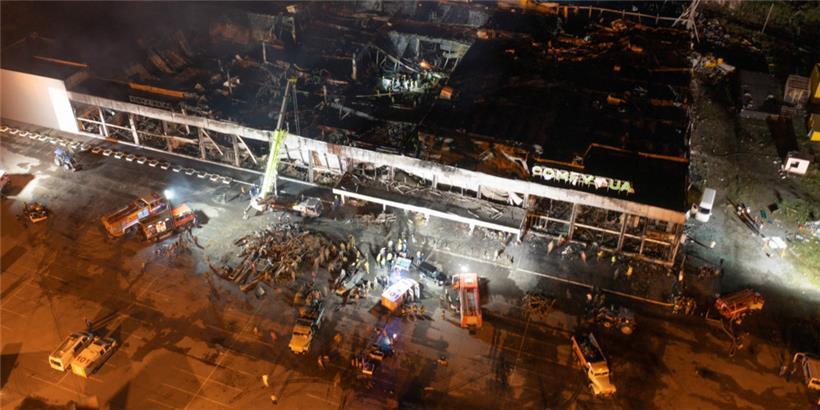 27.06.2022, Ukraine, Krementschuk: Feuerwehrleute des staatlichen ukrainischen Katastrophenschutzes arbeiten an einem Brand in einem Einkaufszentrum nach einem Raketenangriff in Krementschuk, Ukraine
