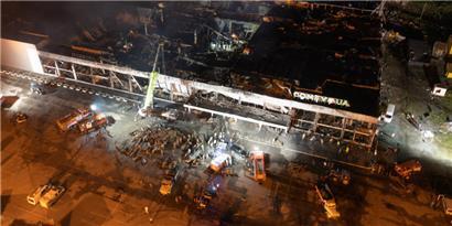 27.06.2022, Ukraine, Krementschuk: Feuerwehrleute des staatlichen ukrainischen Katastrophenschutzes arbeiten an einem Brand in einem Einkaufszentrum nach einem Raketenangriff in Krementschuk, Ukraine
