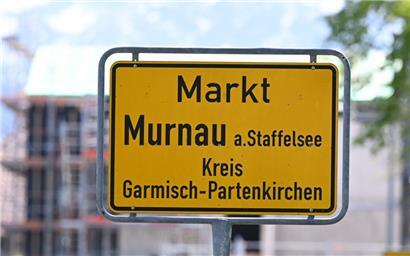 29.04.2024, Murnau Am Staffelsee: Das Ortsschild von Murnau. Bei einem Einkaufszentrum an dem am Samstagabend zwei Männer aus der Ukraine getötet worden sind, haben Menschen Blumen und Plakate niedergelegt. Die beiden getötete Ukrainer waren Armeeangehörige. Foto: Angelika Warmuth/dpa +++ dpa-Bildfunk +++
