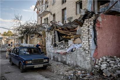 29.07.2022, Ukraine, Slowjansk: Ein Mann raucht vor seinem Auto, während er die Ruinen von Wohngebäuden betrachtet, nachdem russische Artilleriegeschosse das Stadtzentrum getroffen haben
