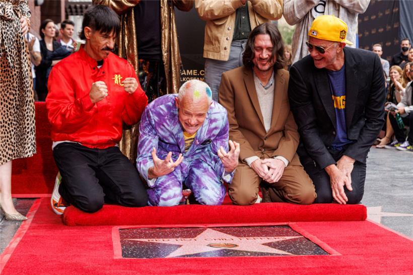 31. März 2022, USA, Los Angeles: Anthony Kiedis (von links), Flea, John Frusciante und Chad Smith von den Red Hot Chili Peppers feiern während einer Zeremonie, bei der die Band mit einem Stern auf dem Hollywood Walk of Fame geehrt wird
