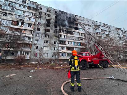 A firefighter looks at a damaged residential building following an air attack in Zaporizhzhia on December 16, 2025, amid the Russian invasion of Ukraine. (Photo by Darya Nazarova (STR Zaporizhzhia) / AFP)

