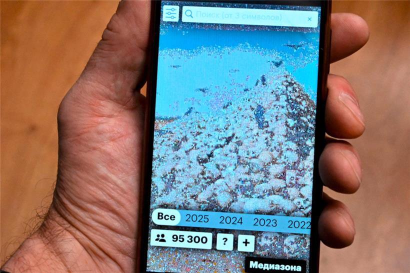 A smartphone screen shows a special website of Russian independent media outlet Mediazona dedicated to the Russian losses in its military campaign in Ukraine featuring an image of Russian artist Vasily Vereshchagin’s painting "The Apotheosis of War" – depicting a huge pile of skulls, made of portraits of killed Russian soldiers, on February 25, 2025….
