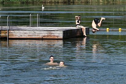 Personen beim Schwimmen und Entspannen an einem klaren Badesee in Echternach im Sommer