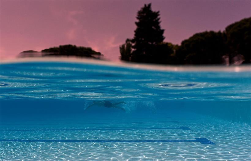 Person kühlt sich im Wasser ab an heißem Sommertag mit Temperaturen bis zu 40 Grad in Europa