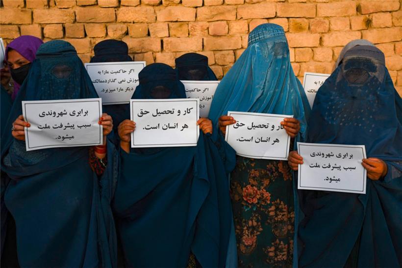 Afghanische Frauen in Burka halten Plakate, während sie am 12. August 2023 in Mazar-i-Sharif für ihr Recht auf Bildung protestieren.
