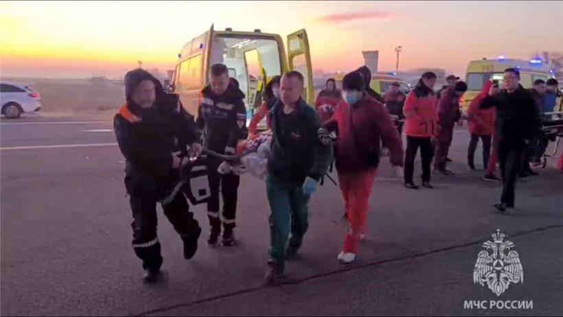Aktau in Kasachstan: Auf diesem vom Pressedienst des russischen Katastrophenschutzministeriums zur Verfügung gestellten Foto tragen Rettungskräfte einen verletzten Passagier, nachdem ein Flugzeug der aserbaidschanischen Fluggesellschaft abgestürzt ist. 
