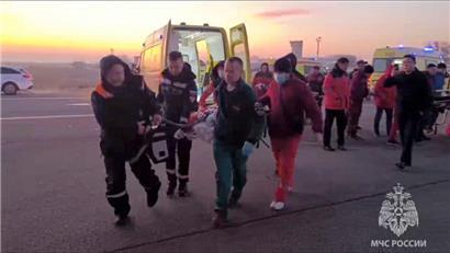 Aktau in Kasachstan: Auf diesem vom Pressedienst des russischen Katastrophenschutzministeriums zur Verfügung gestellten Foto tragen Rettungskräfte einen verletzten Passagier, nachdem ein Flugzeug der aserbaidschanischen Fluggesellschaft abgestürzt ist. 
