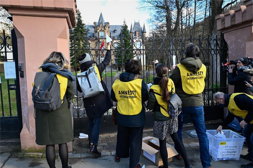 Aktivisten werfen die Petition über das Eingangstor
