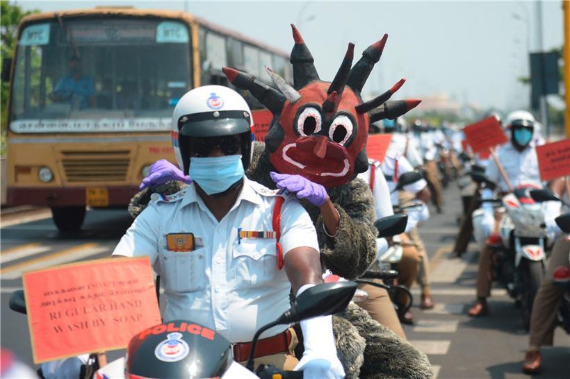 Als Coronavirus verkleidete Polizisten fordern in Neu-Delhi zum Händewaschen auf
