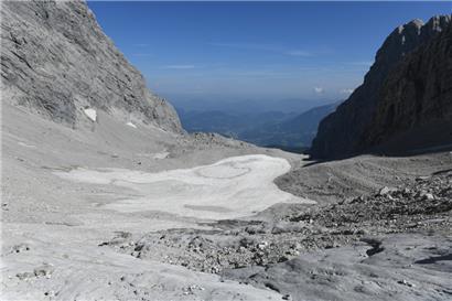 Altschnee und Geröll liegen im September 2021 auf dem kleinen Überrest des Watzmanngletschers. 

