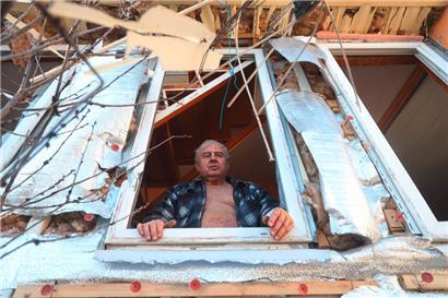 Am 21. März am Stadtrand von Odessa: Ein Mann schaut aus dem Fenster seines nach dem Beschuss durch russische Kriegsschiffe teilweise zerstörten Hauses
