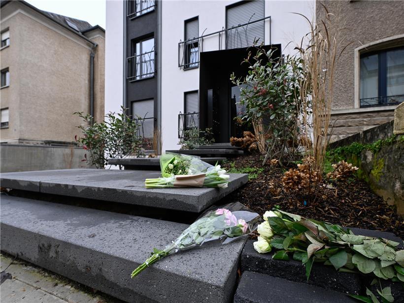 Menschen legen am Tag nach Gewalttat Blumen vor Mehrparteienhaus in Avenue de la Faïencerie nieder