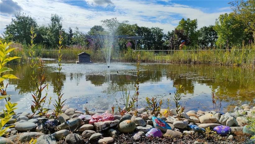 Am Teich im Garten des Hauses Omega erinnern bunte Steine an die Verstorbenen der Palliativ-Einrichtung
