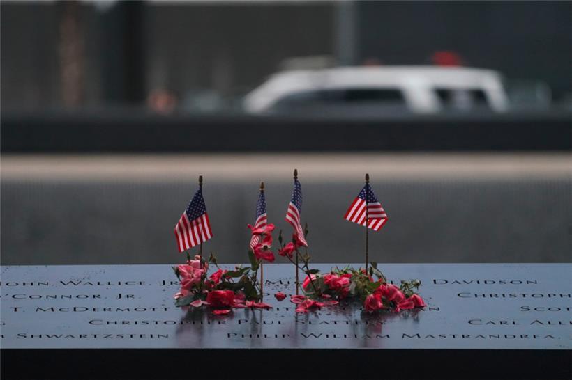 Amerikanische Flaggen und Blumen säumen den Gedenkpool am National September 11 Memorial anlässlich des 22. Jahrestages des Terroranschlags auf das World Trade Center am 11. September 2023 in New York
