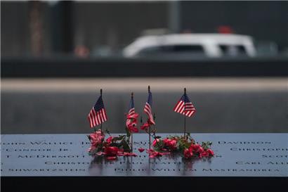 Amerikanische Flaggen und Blumen säumen den Gedenkpool am National September 11 Memorial anlässlich des 22. Jahrestages des Terroranschlags auf das World Trade Center am 11. September 2023 in New York
