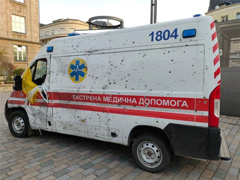 An dem weißen Rettungsfahrzeug zeugen Einschusslöscher von der aktuellen Situation in der Ukraine 
