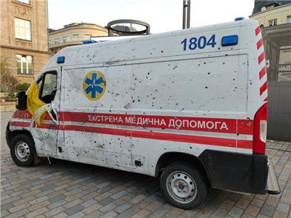 An dem weißen Rettungsfahrzeug zeugen Einschusslöscher von der aktuellen Situation in der Ukraine 
