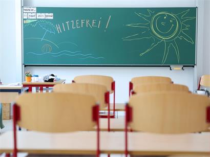 Grundschultafel mit handgeschriebenem „Hitzefrei!“ Hinweis für Schüler und Sommerferienbeginn