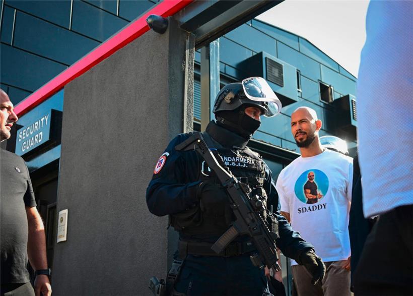 Andrew Tate wird nach einer Polizeirazzia in seinem Haus am Stadtrand von Bukarest zum Verhör geführt
