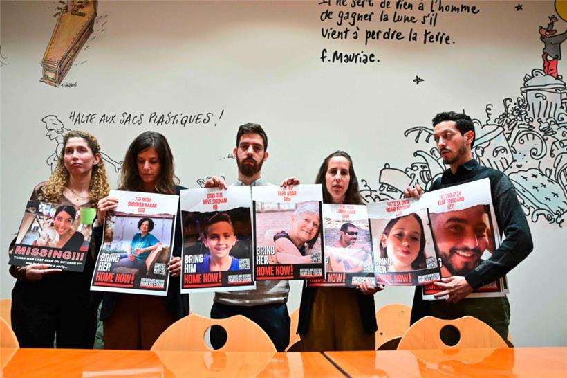 Angehörige von Geiseln halten während einer Pressekonferenz in Paris Bilder ihrer Verwandten hoch, unter ihnen die im Beitrag erwähnte Adva Adar (2.v.r.), die ein Bild ihrer Großmutter Jafa Adar und ihres Cousins Tamir Adar zeigt
