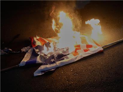 Anhänger der iranischen Regierung zünden bei Protest symbolisch US-amerikanische und israelische Fahnen an