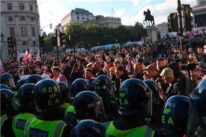Anhänger des britischen Rechtsextremisten Tommy Robinson, dessen richtiger Name Stephen Yaxley-Lennon ist, stehen während einer „Free Speech“-Demonstration im Zentrum Londons am 13. September 2025 einer Polizeikette gegenüber
