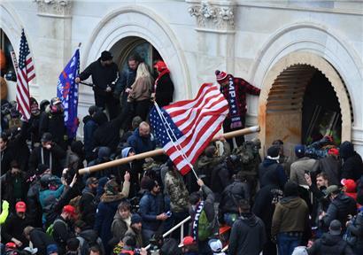 Anhänger des damaligen US-Präsidenten Donald Trump stürmen das Kapitolgebäude, wo die Abgeordneten den Sieg des gewählten Präsidenten Biden bei der Wahl im November bestätigen sollten
