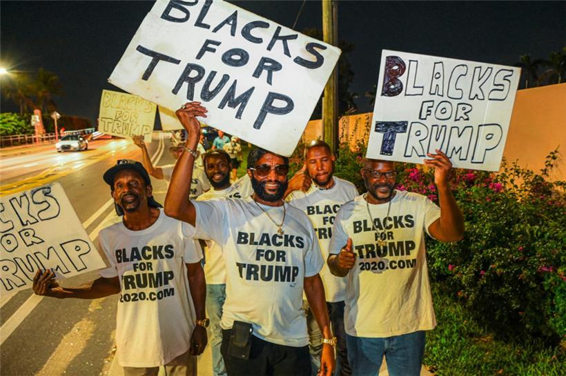 Anhänger des ehemaligen US-Präsidenten Donald Trump halten Schilder vor Trumps Mar-A-Lago-Residenz in West Palm Beach, Florida, am 15. November 2022
