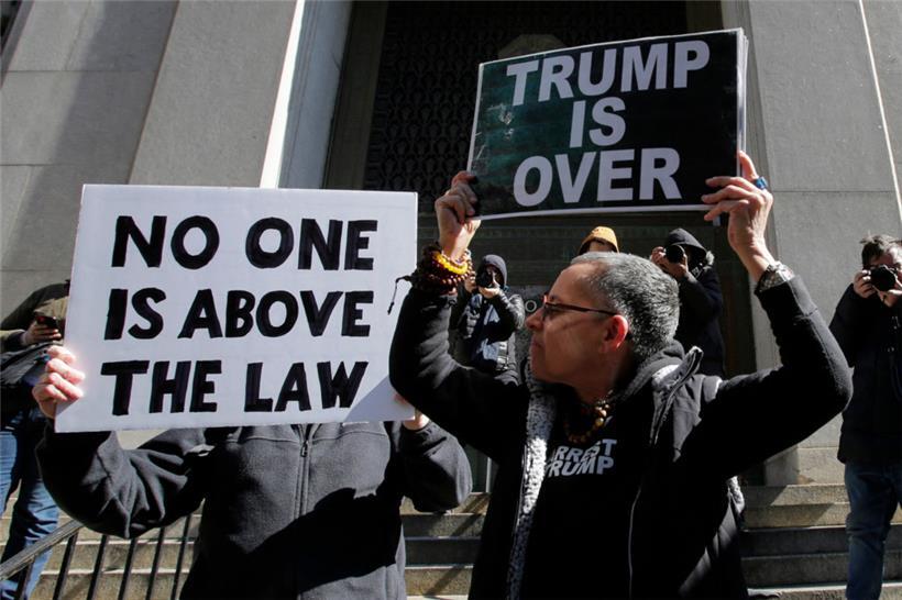 Anti-Trump-Demonstranten halten vor der Staatsanwaltschaft von Manhattan Plakate hoch
