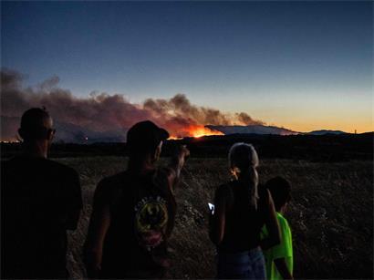 Anwohner beobachten Waldbrand hinter Bergrücken in Aspres, Pyrénées-Orientales, Südfrankreich, nahe Ortschaft Millas