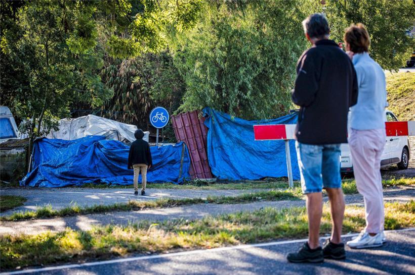 Anwohner stehen an der Unfallstelle, die mit blauen Planen abgedeckt ist. In den Niederlanden ist ein Lastzug in ein Nachbarschaftsfest gekracht und hat mehrere Menschen in den Tod gerissen.
