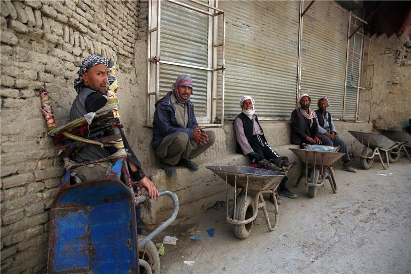 Arbeiter sitzen neben ihren Schubkarren, während sie vor dem bevorstehenden Fastenmonat Ramadan auf Arbeit warten. Muslime auf der ganzen Welt nehmen am Ramadan teil.
