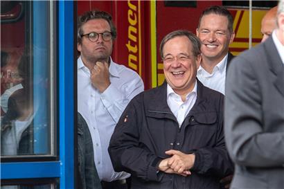 Armin Laschet (2. v.l., CDU), Ministerpräsident von Nordrhein-Westfalen, lacht, während Bundespräsident Steinmeier (nicht im Bild) ein Pressestatement gibt. Links steht Christian Wiermer, Sprecher der Landesregierung.
