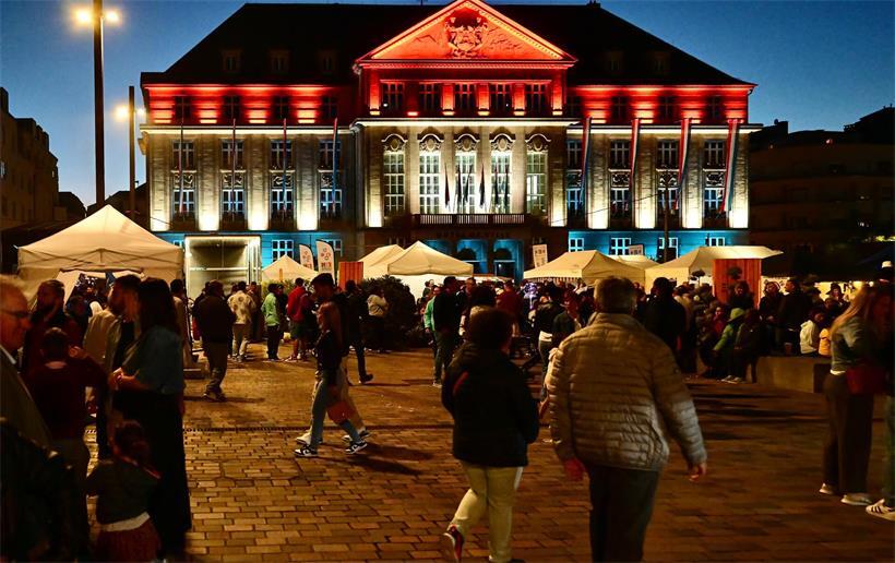 Das Programm zum Nationalfeiertag 2026 – Wo wann gefeiert werden kann Menschen tanzen und feiern vor dem Rathaus bei einer jährlichen Open-Air-Veranstaltung
