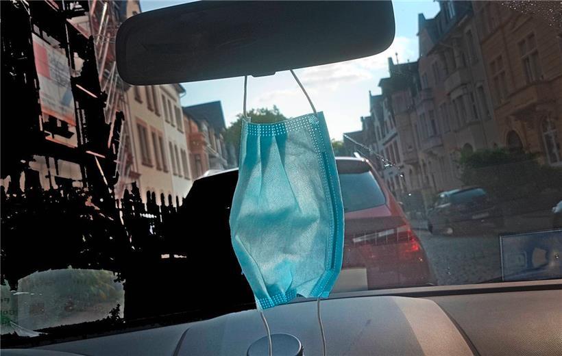 Auch wenn sie nicht an den Rückspiegel darf – die Mund und Nase bedeckende Maske gilt gesetzlich als Schutzmittel gegen Covid, der Schutz aus Plexiglas hingegen wurde nun disqualifiziert
