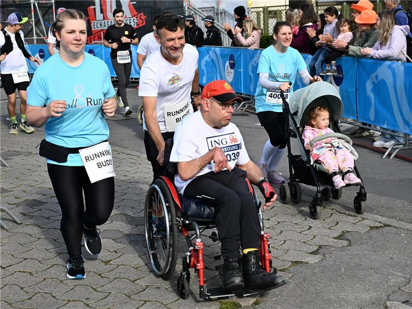 Menschen verschiedener Altersgruppen laufen gemeinsam beim inklusiven Roll & Run Event auf dem Glacis