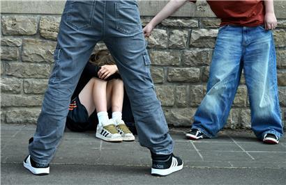 Schulhof-Szene zeigt Kinder in Konflikt, Symbol für Mobbing und Machtkämpfe unter Schülern.