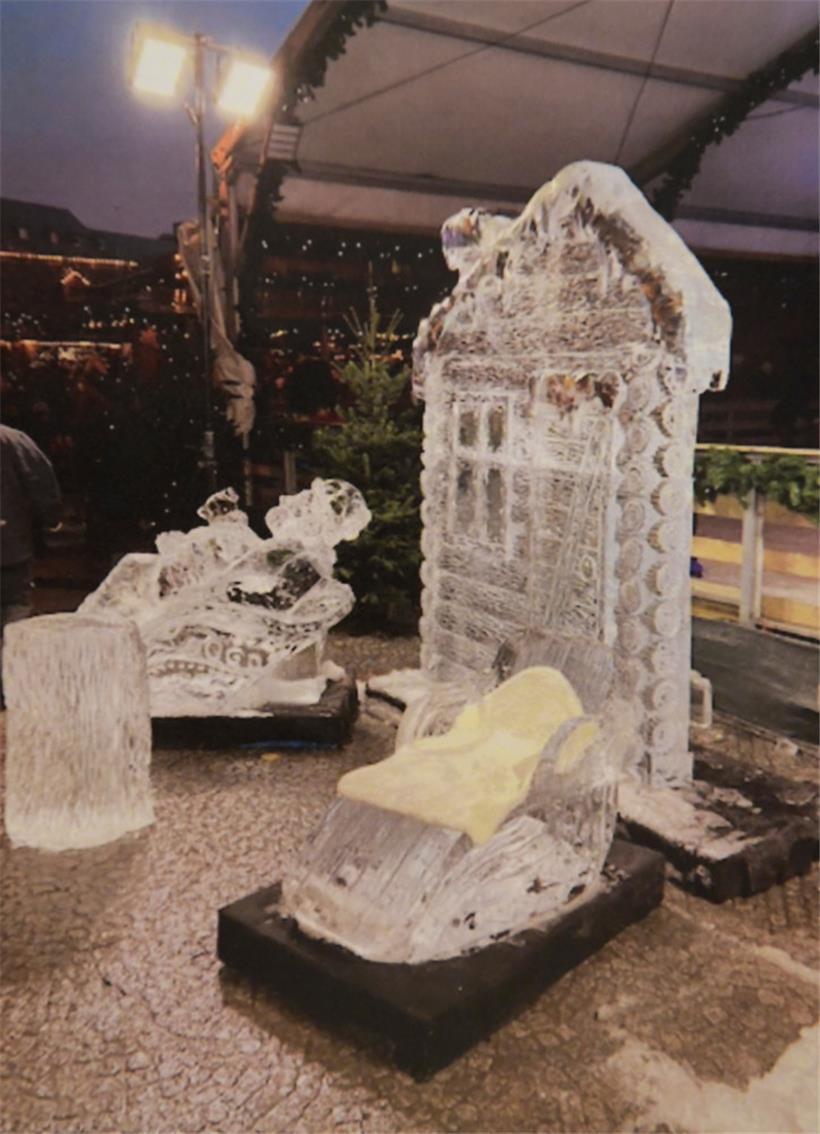 Auf dem aus Eis geformten Schlitten im Vordergrund liegt ein Fell, auf den sich Menschen setzen können, um Fotos zu machen. Dahinter ist der Teil der Skulptur zu sehen, die auf den zweijährigen Emran fiel. Dieser stellt eine Holzchalet-Fassade dar.
