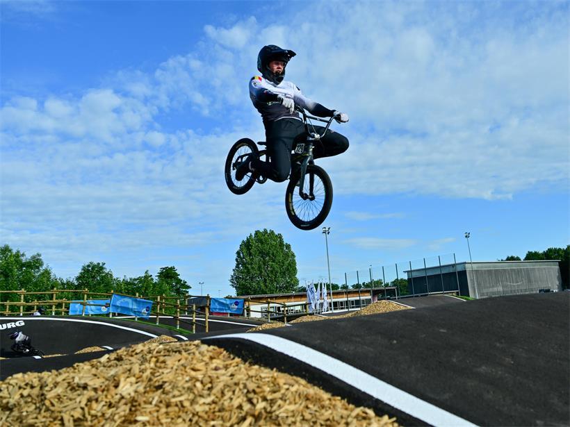 BMX-Fahrer springt hoch auf neuer BMX-Piste bei feierlicher Einweihung im Freien