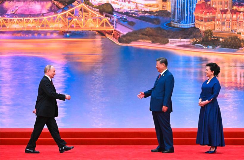 Auf diesem von der russischen Staatsagentur Sputnik verbreiteten Foto nehmen Russlands Präsident Wladimir Putin, Chinas Präsident Xi Jinping und dessen Ehefrau Peng Liyuan an einer Willkommenszeremonie teil
