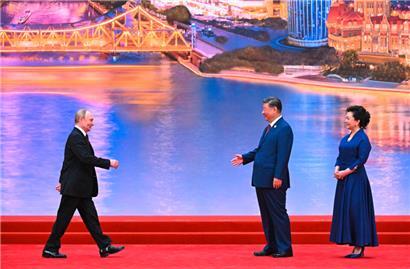 Auf diesem von der russischen Staatsagentur Sputnik verbreiteten Foto nehmen Russlands Präsident Wladimir Putin, Chinas Präsident Xi Jinping und dessen Ehefrau Peng Liyuan an einer Willkommenszeremonie teil

