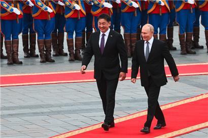 Auf diesem von der russischen staatlichen Agentur Sputnik verbreiteten Pool-Foto schreiten der russische Präsident Wladimir Putin und der mongolische Präsident Uchnaagiin Chürelsüch während einer offiziellen Begrüßungszeremonie über den roten Teppich
