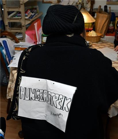 Auf ein Blatt Papier hat Astgik Manukyan das Wort „Hungerstreik“ geschrieben und dieses an ihrem Rücken befestigt
